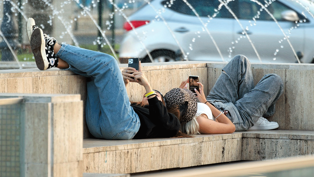 Νέοι σκρολάρουν στο κινητό τους τηλέφωνο