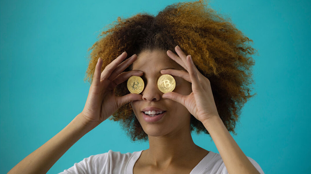 Γυναίκα κρατάει νομίσματα μπροστά στα μάτια της
