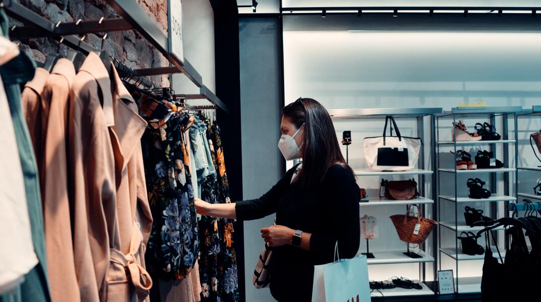 Γυναίκα κοιτάζει ρούχα σε κατάστημα ρούχων