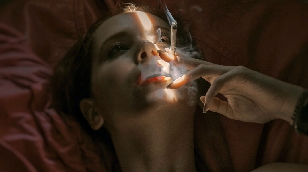 Γυναίκα ξαπλωμένη καπνίζει