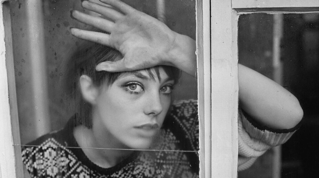 Ασπρόμαυρη φωτογραφία της Jane Birkin πίσω από ένα τζάμι