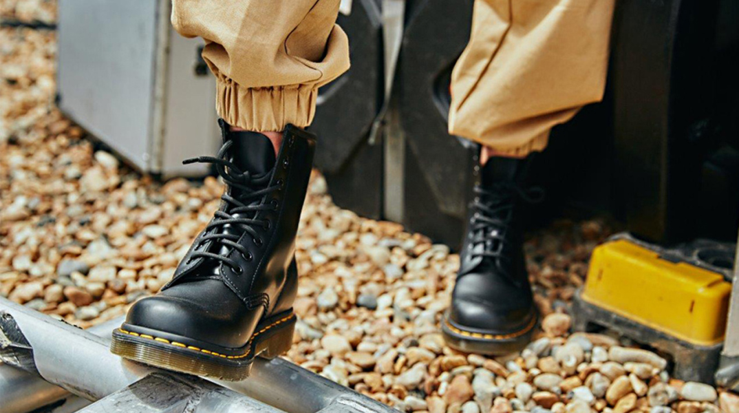 Φωτογραφία εστιασμένη σε πόδια που φορούν μαύρα μποτάκια