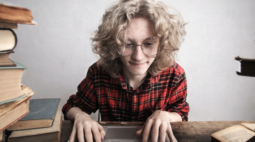 Γυναίκα με γυαλιά πληκτρολογεί σε laptop