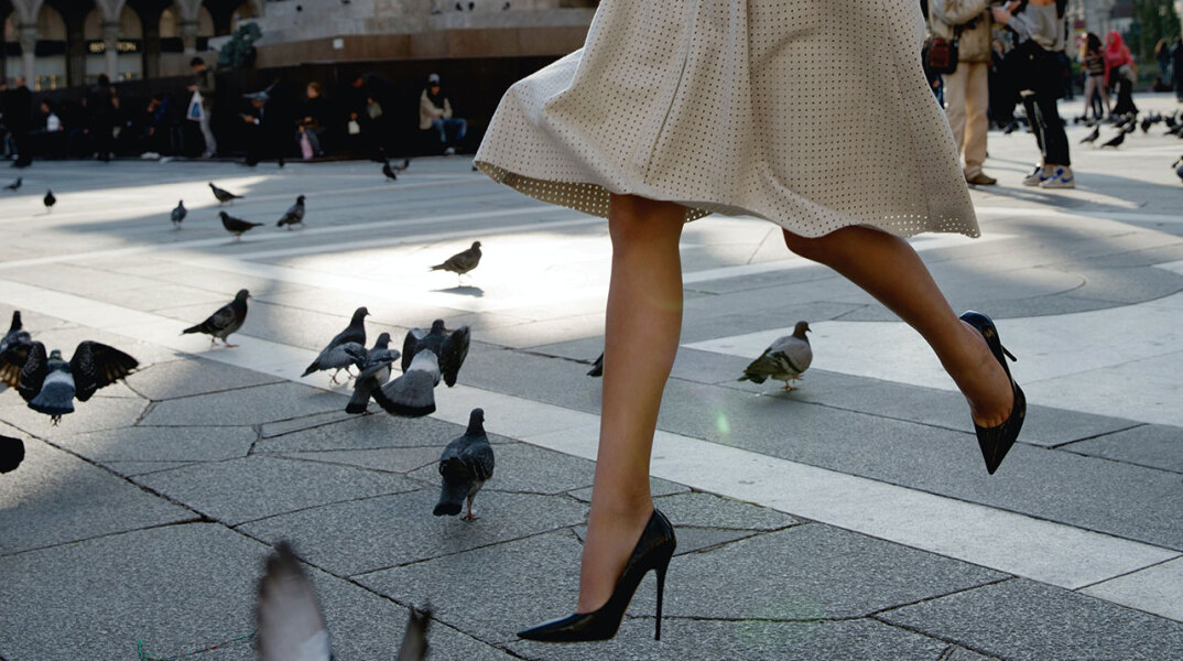 Γυναίκα περπατάει με τακούνια σε πλατεία