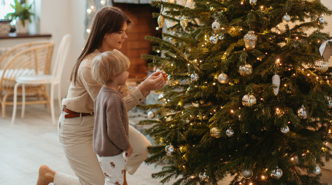 Μαμά και παιδί στολίζουν χριστουγεννιάτικο δέντρο