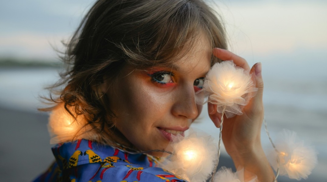 Νέα κοπέλα με κοντά μαλλιά και πορτοκαλί σκιά ματιών 