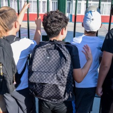 Μαθητές με τις τσάντες τους στην πλάτη αναμένουν να ανοίξει η πόρτα του σχολείου τους
