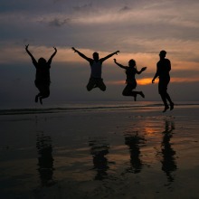 Άνθρωποι στην παραλία που χοροπηδούν