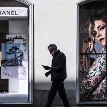 Άντρας με προστατευτική μάσκα περνάει έξω από κατάστημα Chanel