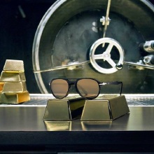 Γυαλιά ηλίου Persol ακουμπισμένα πάνω σε πλάκες χρυσού