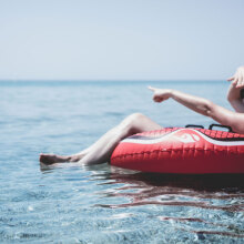 Γυναίκα κάθεται σε φουσκωτή κουλούρα στην θάλασσα