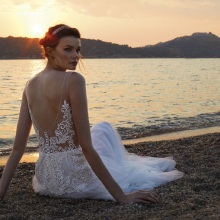 Κοπέλα με νυφικό καθισμένη στην άμμο