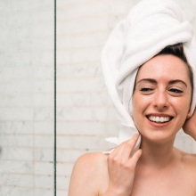 Κοπέλα με πετσέτα στα μαλλιά και το σώμα βγαίνει από το ντους