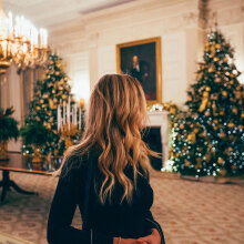 Γυναικα με κεφάλι γυρισμένο δεξιά και φόντο σαλόνι στολισμένο με χριστουγεννιάτικο και χριστουγεννιάτικο δέντρο