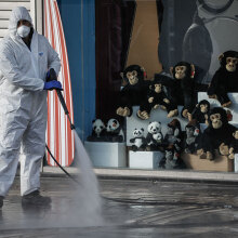 Εργαζόμενος στον Δήμο Αθηναίων με προστατευτική στολή για τον κορωνοϊό προχωρεί σε απολύμανση στο Μοναστηράκι