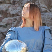 Κοπέλα με μπλε ρούχα και ξανθοχάλκινα μαλλιά με γυρισμένο πρόσωπο στα αριστερά