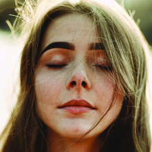 Πορτραίτο νέας κοπέλας με καστανά μαλλιά και κλειστά μάτια