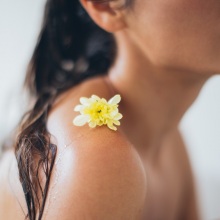 Κοπέλα στο μπάνιο με λουλούδι στον ώμο