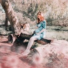 Έγκυος γυναίκα κρατά την κοιλιά της σε δάσος