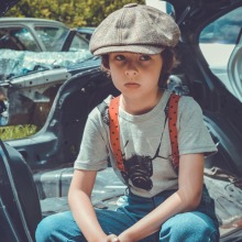 Παιδί με μπερέ που κάθεται σε αυτοκίνητο