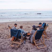 Τέσσερις φίλοι κάθονται σε καρέκλες στην παραλία