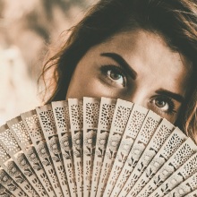 Μια γυναίκα κρατά μια βεντάλια.