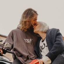 Άντρας φιλάει τη γυναίκα στο μέτωπο ενώ σκέκονται πάνω στη μηχανή