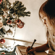 Μικρό κοριτσάκι δίπλα στο χριστουγεννιάτικο δέντρο