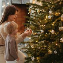 Μαμά και παιδί στολίζουν το χριστουγεννιάτικο δέντρο
