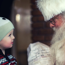 Ένα μικρό παιδάκι στέκεται μπροστά από τον Άγιο Βασίλη