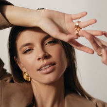 Μελαχρινή κοπέλα κοιτάει την κάμερα και χαμογελάει