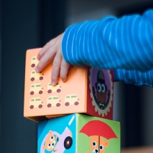 Χέρια παιδιού σε παιχνίδι με κύβους