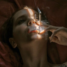 Γυναίκα ξαπλωμένη καπνίζει