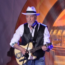 Ο Ρόμπερτ Ουίλιαμς κρατά την κιθάρα του σε συναυλία το 2018