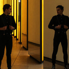 Άντρας ντυμένος στα μαύρα, που κοιτιέται στον καθρέφτη