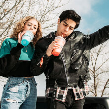 Έφηβοι, κορίτσι και αγόρι πίνουν αναψυκτικό