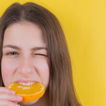 Κοπέλα δαγκώνει πορτοκάλι