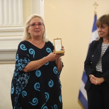 Η Μαρία Τσιαλέρα κρατά στα χέρια τον Αργυρό Σταυρό του Τάγματος της Ευποιΐας και στέκεται συγκινημένη δίπλα στην Πρόεδρο της Δημοκρατίας, Κατερίνα Σακκελαροπούλου