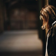 Κοπέλα με κρυμμένο το πρόσωπο κάθεται στα δεξιά της φωτογραφίας - Εικόνα που παραπέμπει στην απεικόνιση θύματος βίας ή επίθεσης