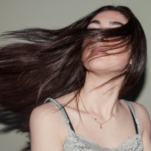 κοπέλα με λαμπερά κάστανα μαλλιά 