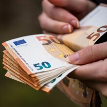 Άνδρας μετρά χαρτονομίσματα των 50 ευρώ