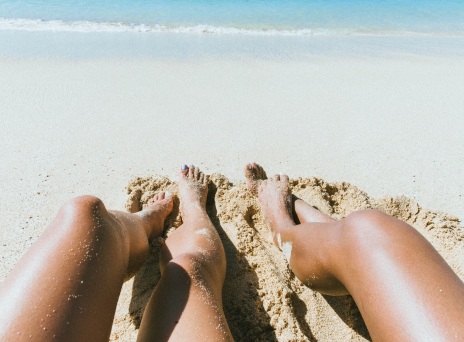 Γυναικεία πόδια στην άμμο παραλίας