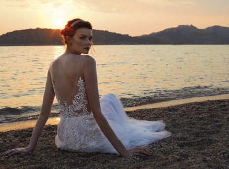 Κοπέλα με νυφικό καθισμένη στην άμμο