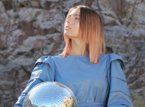 Κοπέλα με μπλε ρούχα και ξανθοχάλκινα μαλλιά με γυρισμένο πρόσωπο στα αριστερά