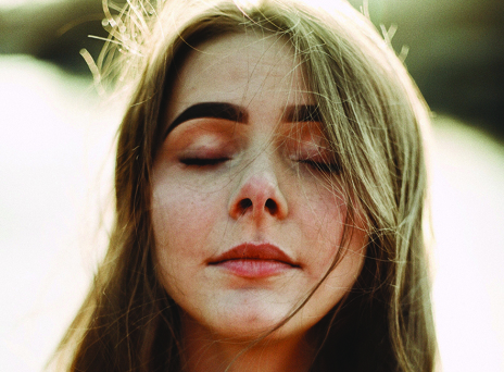 Πορτραίτο νέας κοπέλας με καστανά μαλλιά και κλειστά μάτια