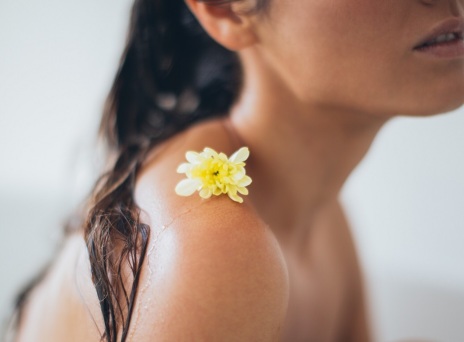 Κοπέλα στο μπάνιο με λουλούδι στον ώμο