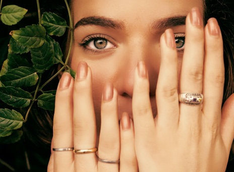 Κοπέλα κρατά τα χέρια της μπροστά στο πρόσωπο δείχνοντας τα νύχια της