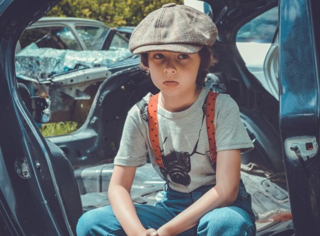 Παιδί με μπερέ που κάθεται σε αυτοκίνητο