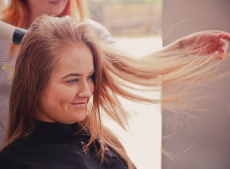 Κοπέλα σε κομμωτήριο, στεγνώνει τα μαλλιά της