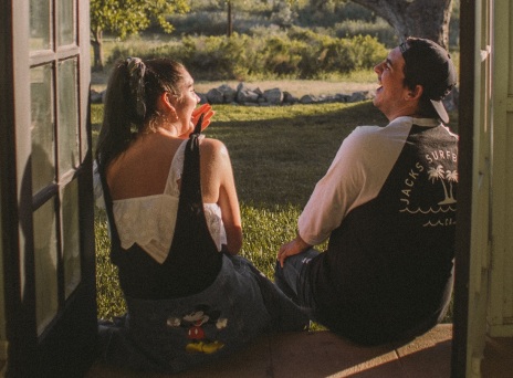 Άντρας και γυναίκα καθιστοί γελάνε